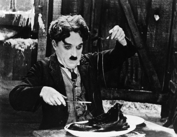 The starving Chaplin boils his shoe and makes a feast of it, The Gold Rush,1925