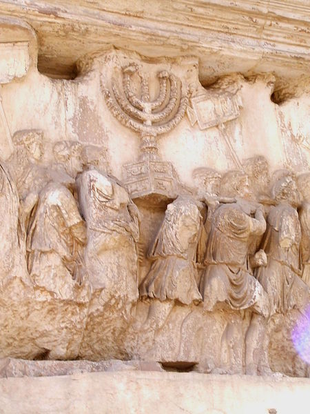 ---This wall relief on the Arch of Titus reveals one of the most troubling scenes in all history, Roman soldiers carrying spoils from the destruction of the Temple of Jerusalem in 70 A.D. The Temple Menorah* and the Table** of the Shewbread shown at an angle, both of solid gold, and the silver trumpets which called the Jews to the festivals. The Romans are in triumphal procession wearing laurel crowns and the ones carrying the Menorah have pillows on their shoulders. The soldiers carry signs commemorating the victories which Titus had won. This group of soldiers is just a few of the hundreds in the actual triumphal procession down Rome's Sacred Way. The whole procession is about to enter the carved arch on the right which reveals the quadriga at the top,---click image for source...